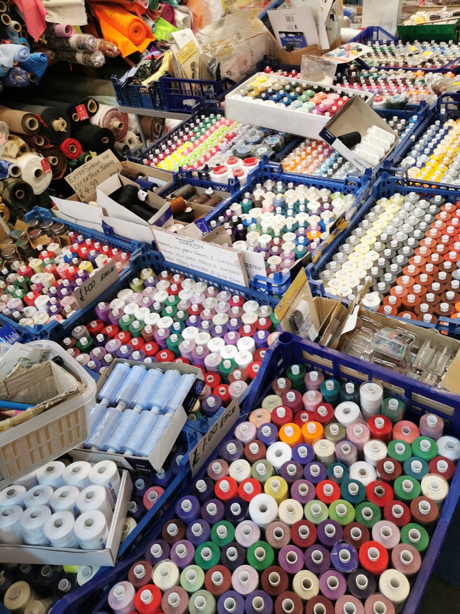 Blue crates packed with reels of sewing thread in hundreds of colours at Z. Butt Textiles, priced £1 each.